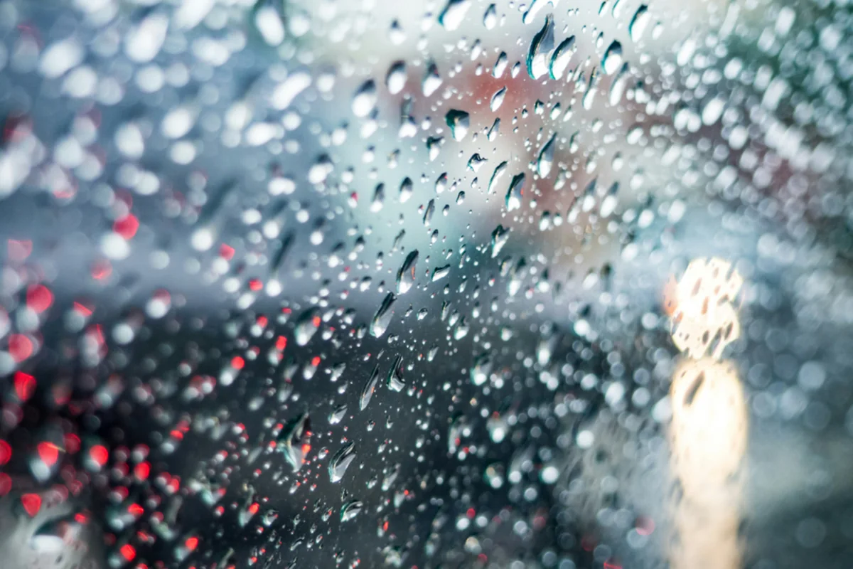 Ventana con gotas de lluvia vista desde dentro, luz gris de un día nublado