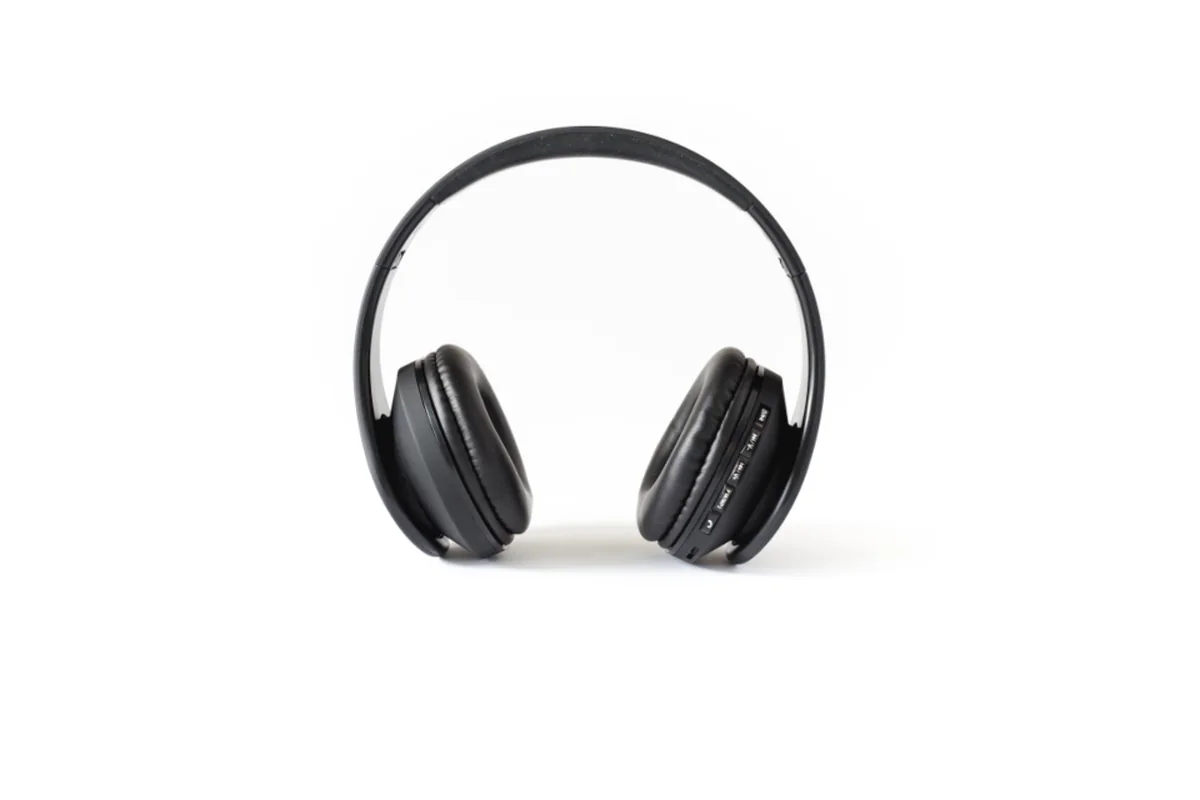Unos auriculares negros de diadema apoyados de frente sobre un fondo blanco