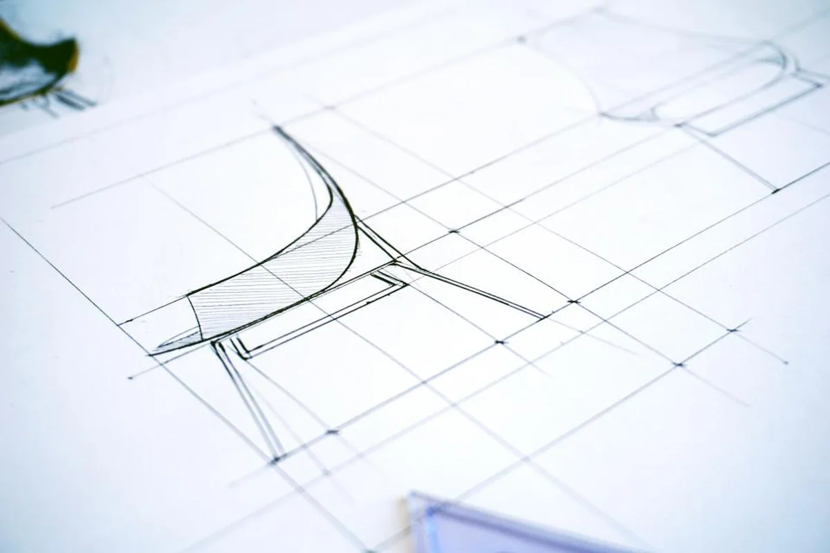 Boceto a lápiz de una silla dibujado sobre una cuadrícula de líneas finas en un papel blanco