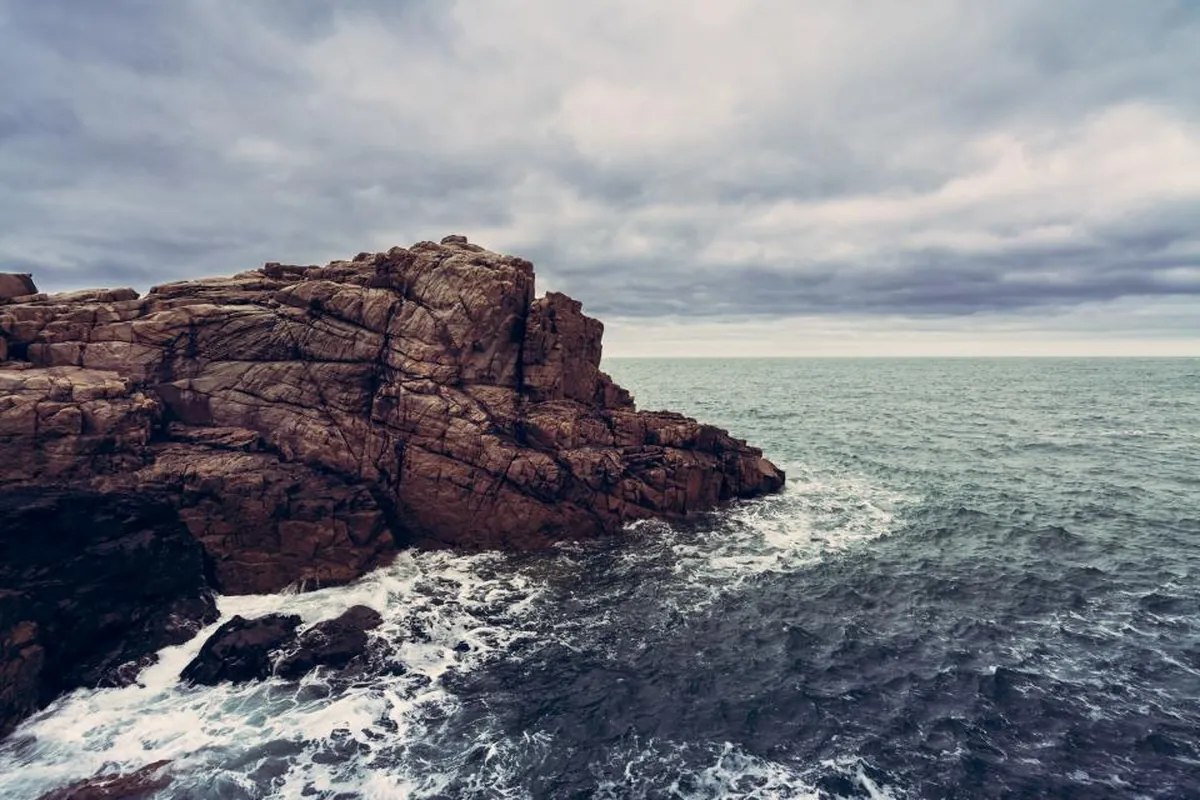 Costa rocosa bajo un cielo nublado y tormentoso