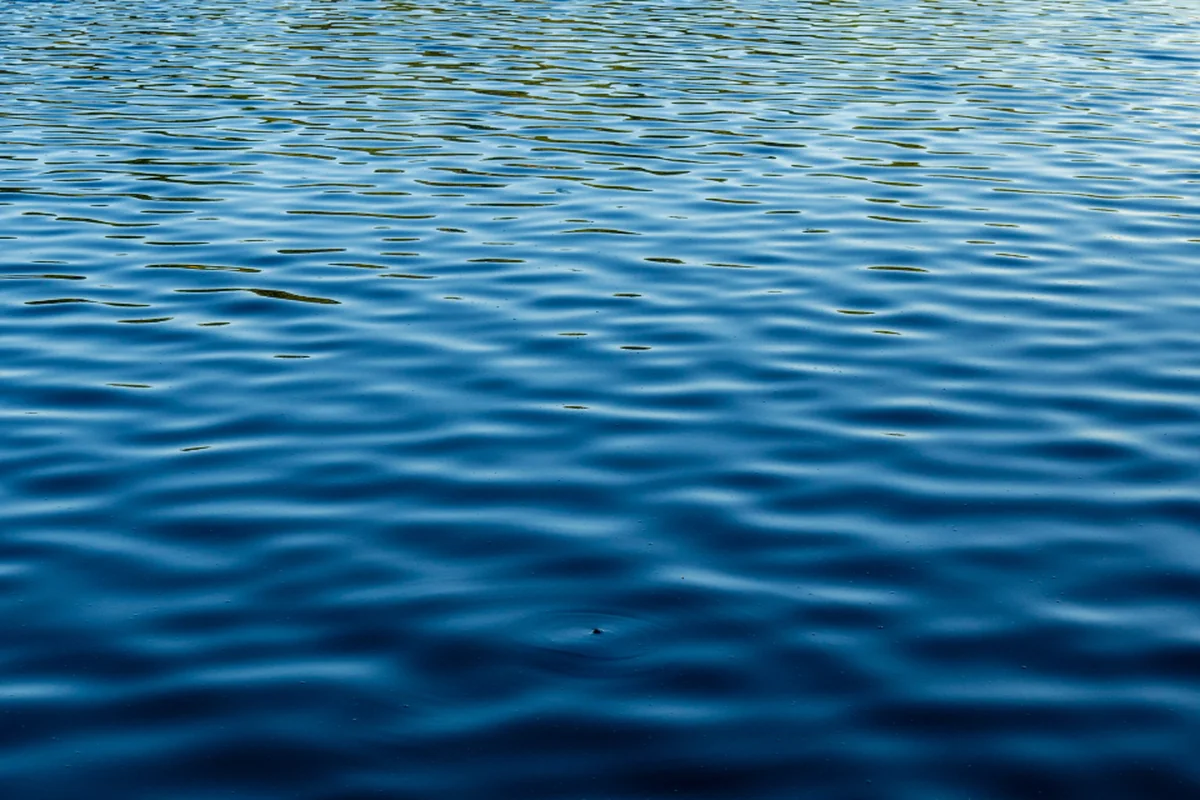 Superficie de agua con ondas concéntricas en tonos azules, vista desde arriba