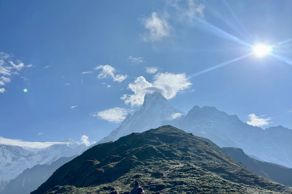 Sendero de hierba en una cresta de montaña con picos al fondo