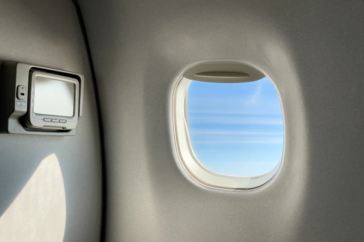 Vista a través de la ventanilla de un avión con cielo despejado