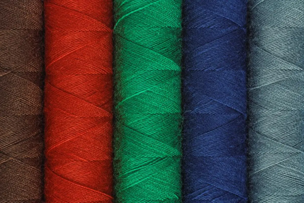 Varios carretes de hilo de colores apilados en fila