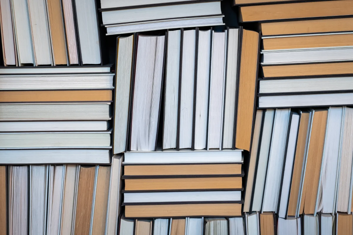Muchos libros apilados en distintas direcciones fotografiados desde arriba