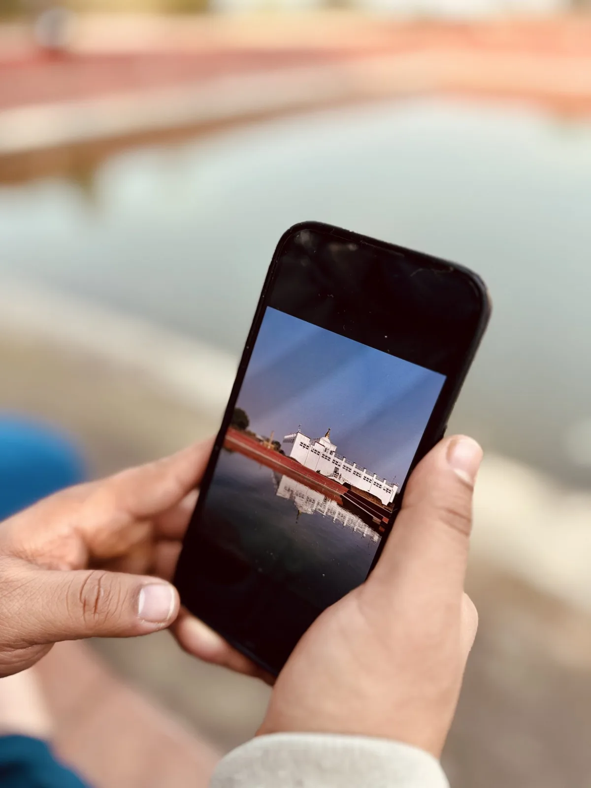 Manos sosteniendo un teléfono móvil mostrando una fotografía en la pantalla