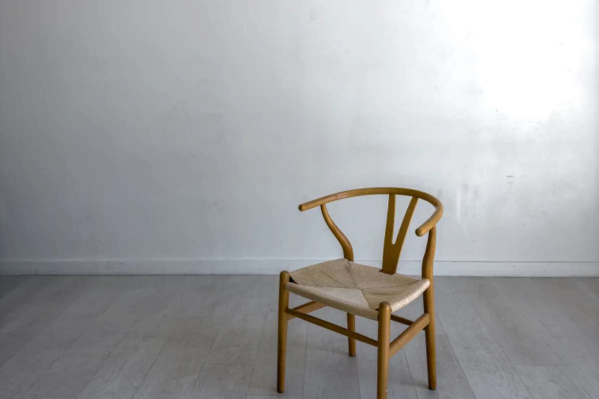 Silla de madera vacía en una sala amplia y luminosa