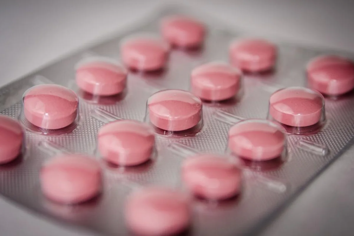 Primer plano de pastillas redondas de color rosa dentro de un blíster plateado