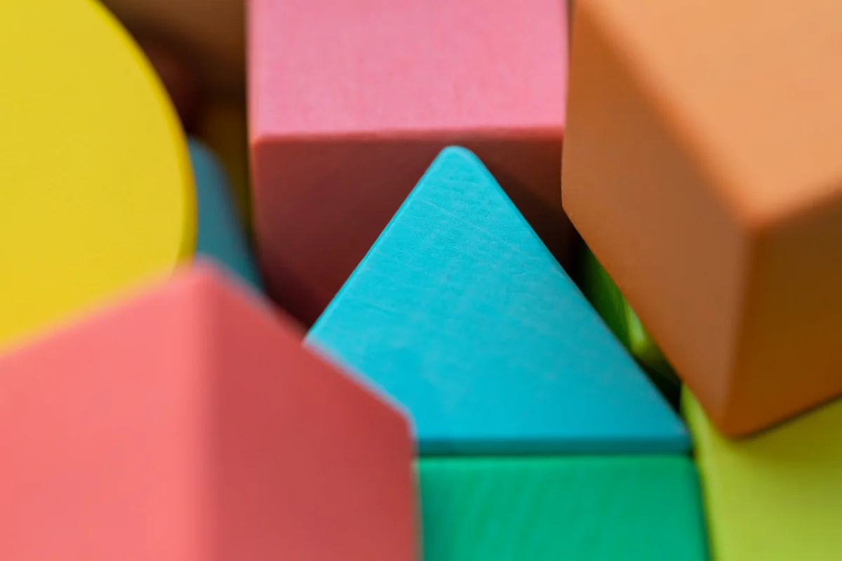 Juguetes de madera de colores en primer plano, sin niños visibles