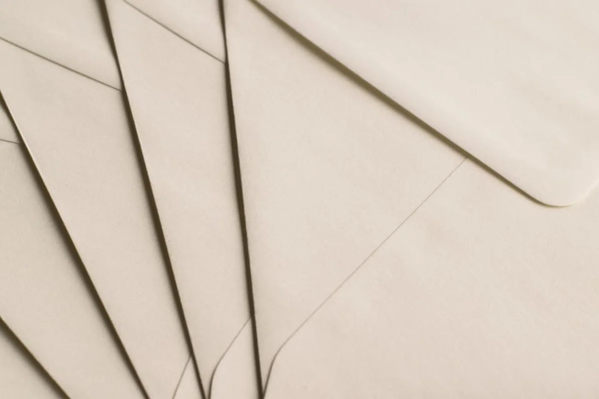 Varios sobres de papel de color beige colocados en abanico, uno encima de otro, sin ningún texto visible
