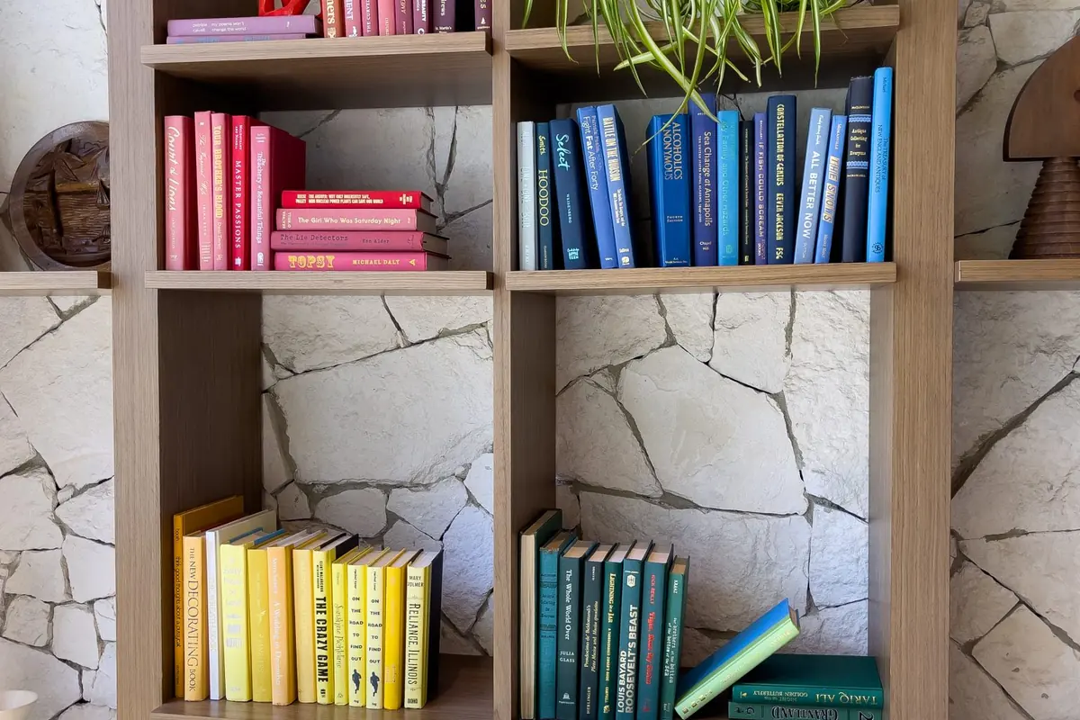 Estantería de libros organizada por colores, composición ordenada y minimalista