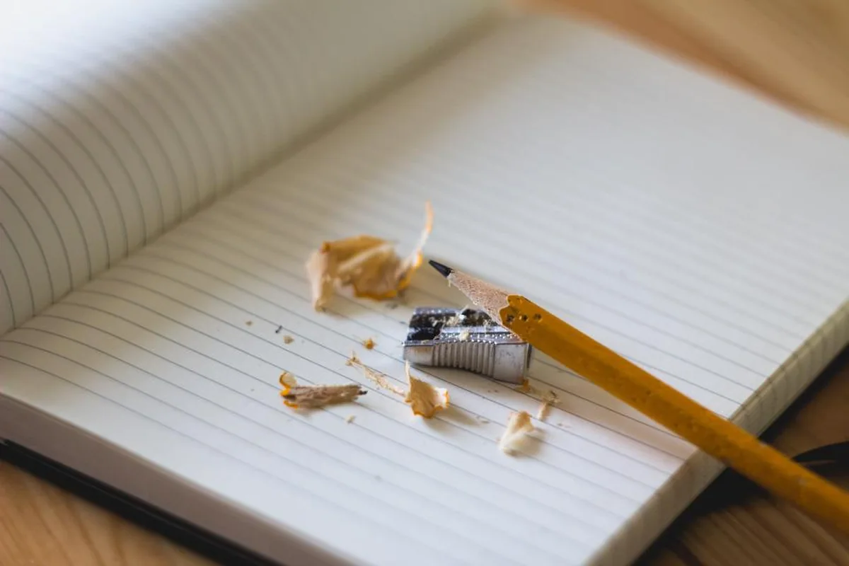 Cuaderno abierto con un sacapuntas y virutas de lápiz sobre las páginas